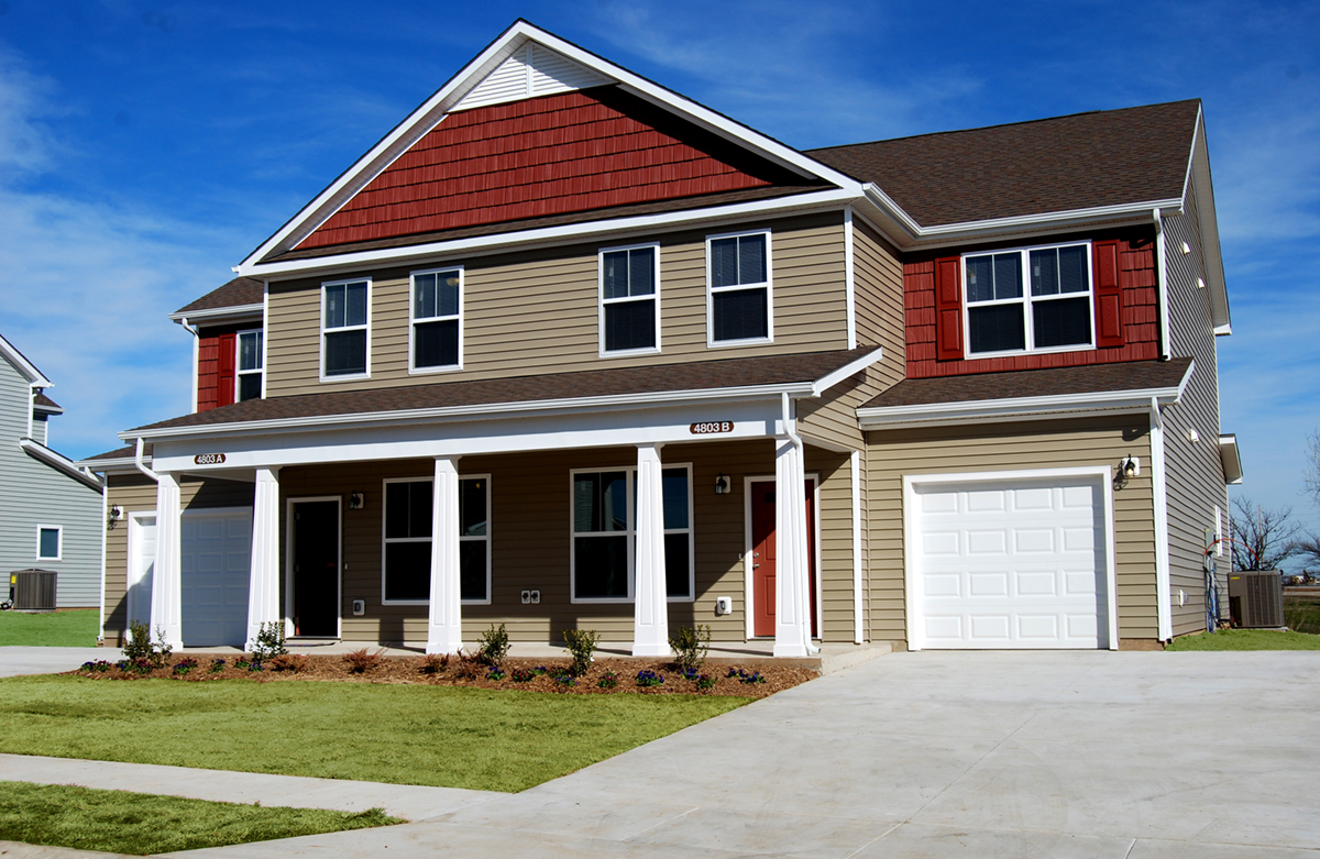 Front view of a home with tan and red siding