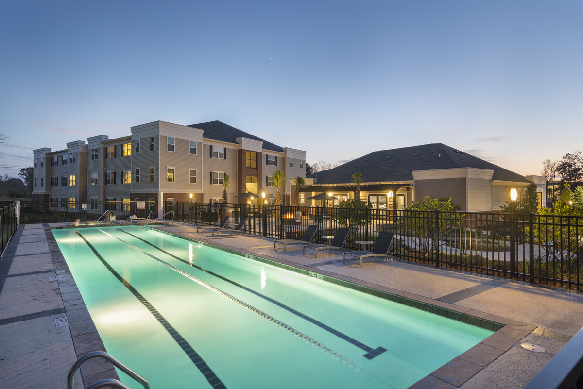 Outdoor pool with lights on at dusk