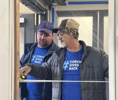 Jeremy Busby and Mike Josey measure framing for a new door.