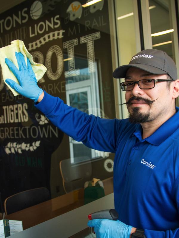 Maintenance technician cleaning windows