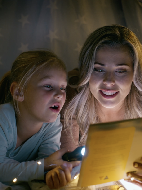 Children in tent reading a book