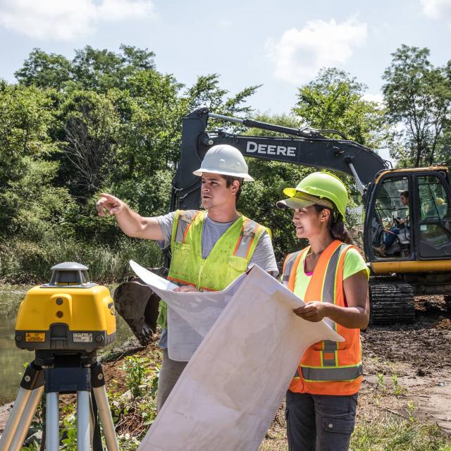 Workers reviewing map and land