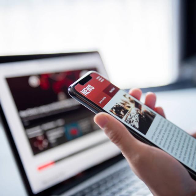 Hand holding a mobile phone looking at Corvias business news