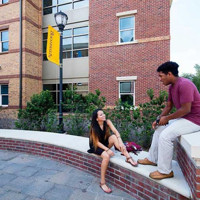 Students sitting outside a residential building