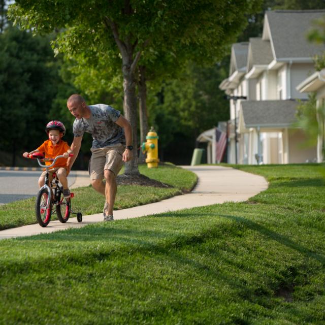 Military Community Dad with Child on Bike