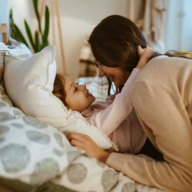 Mother putting child to bed
