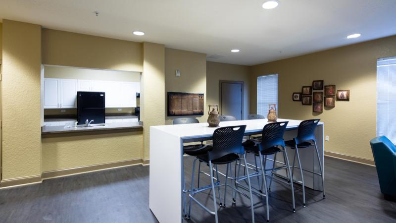 Inside of a dining room looking into a kitchen