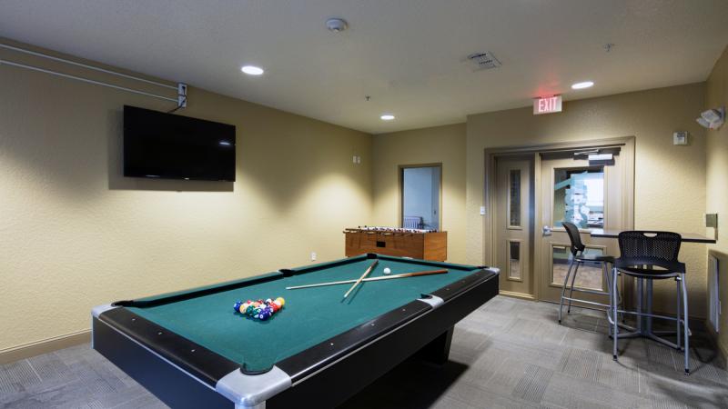 Room with a pool table and TV