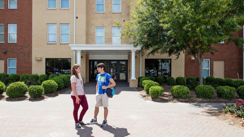 Two students talking outside a building