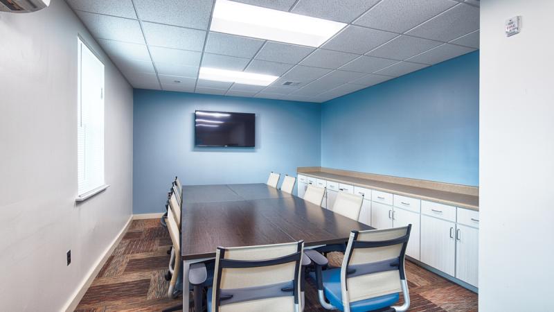 Small meeting room with a long table and chairs