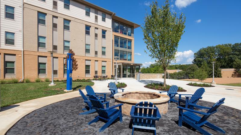 A firepit with chairs outside a building