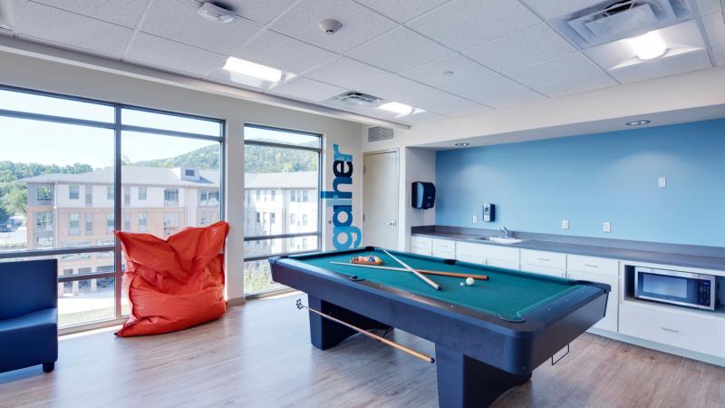 Room with a pool table and chairs