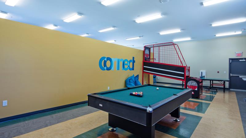 Game room with a pool table and basketball hoop