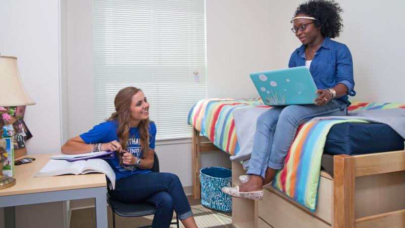 Two female students in a bedroom 