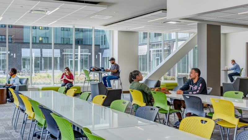 Students studying in a large room with tables