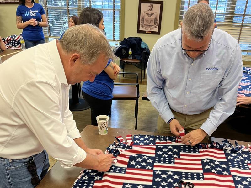  Corvias CEO Chris Wilson and Michael Paz-Torres, Regulatory Compliance Specialist, assemble blankets that will be donated to a unit at Fort Riley who will soon deploy.