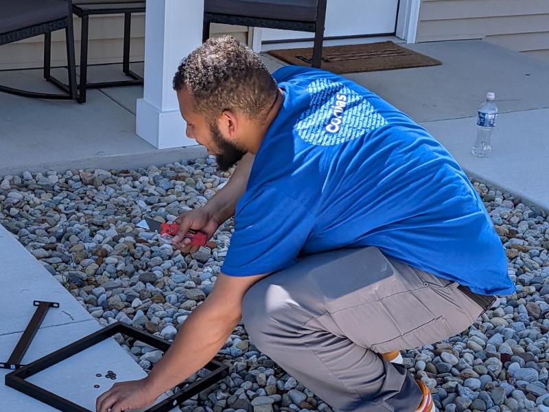 Corvias Maintenance Technician, Justin Torres assembles a patio set for residents to use.