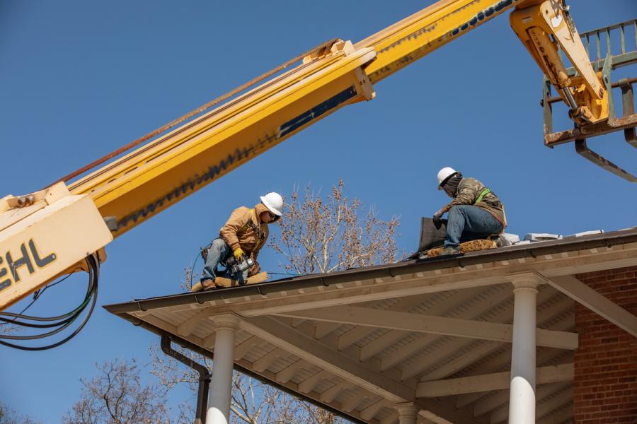 Construction team replacing roof on a historic home