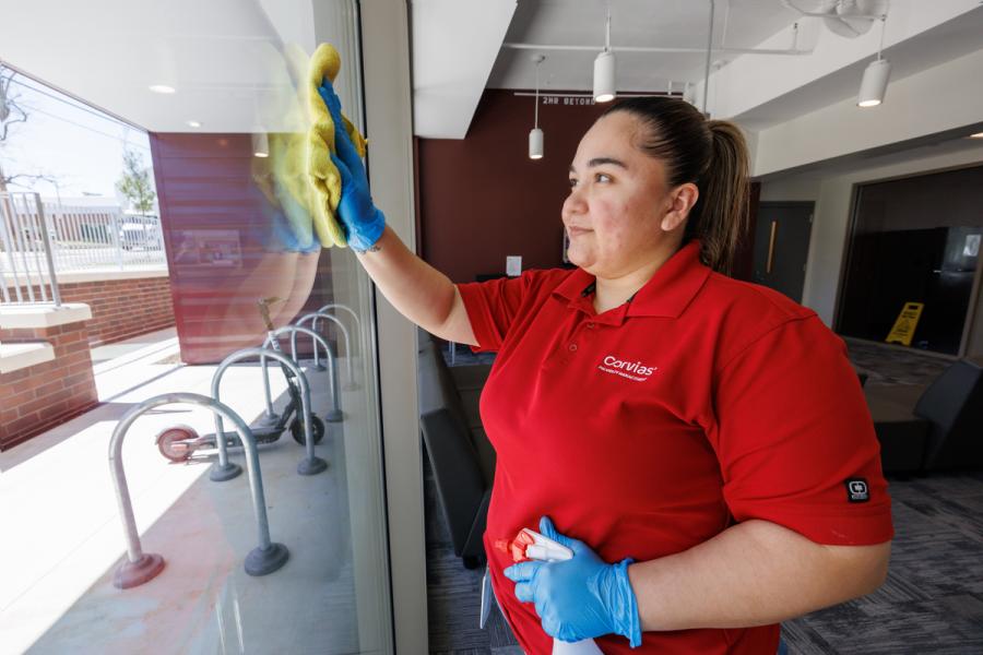 Corvias Property Management employee cleans window