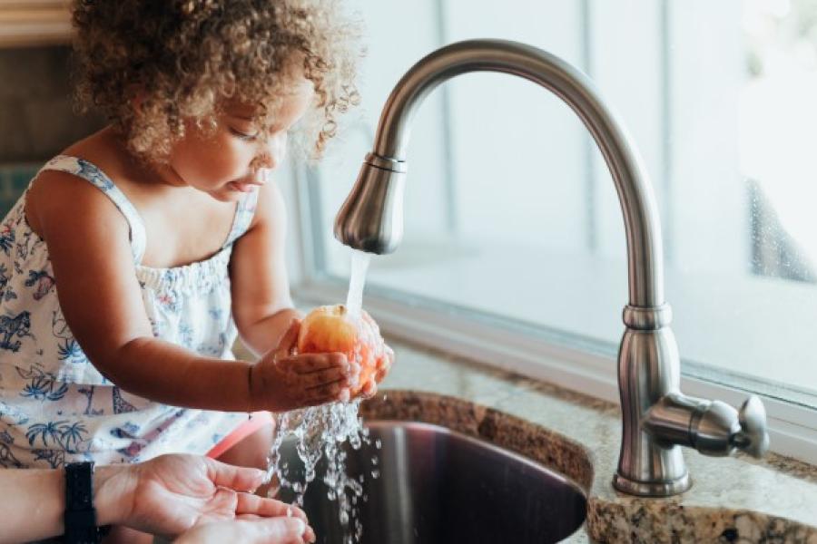 Girl Washing Apple with Filtered Water